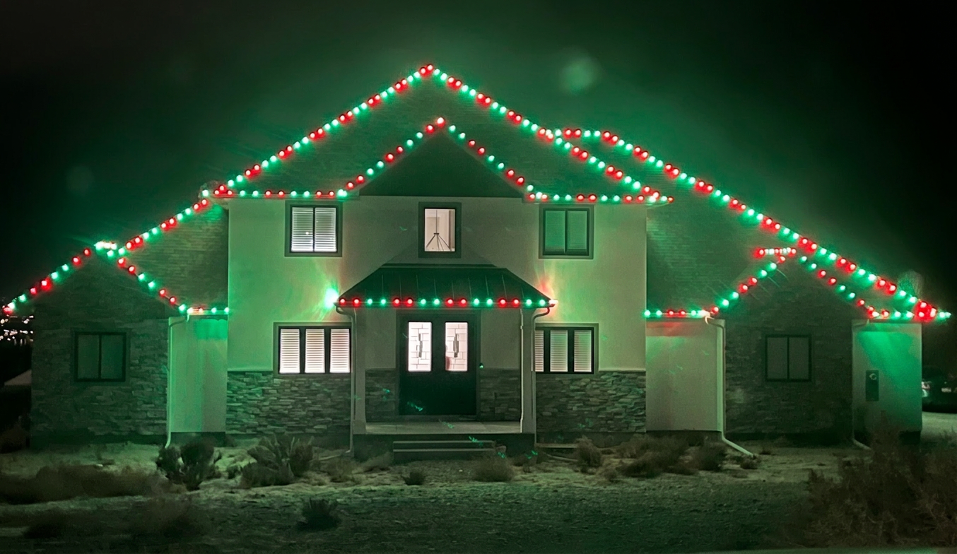 Idaho home with red and green C9 Christmas lights on every roofline